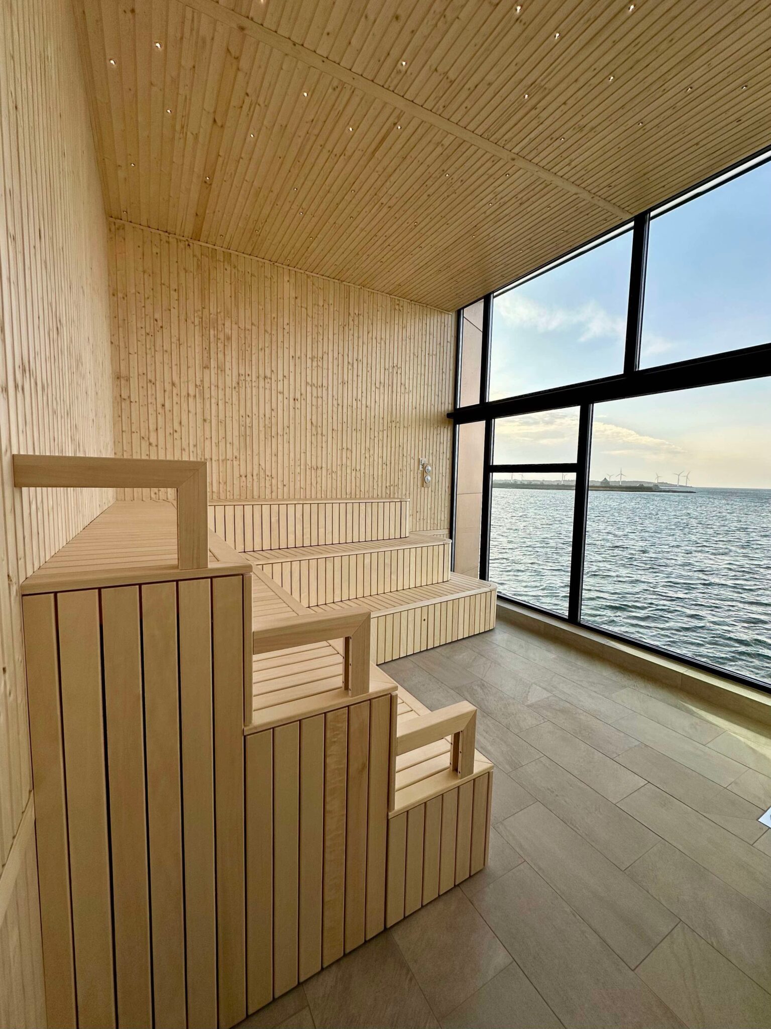 Bastulavar i ljust trä intill kallbadhusets stora fönster mot havet.